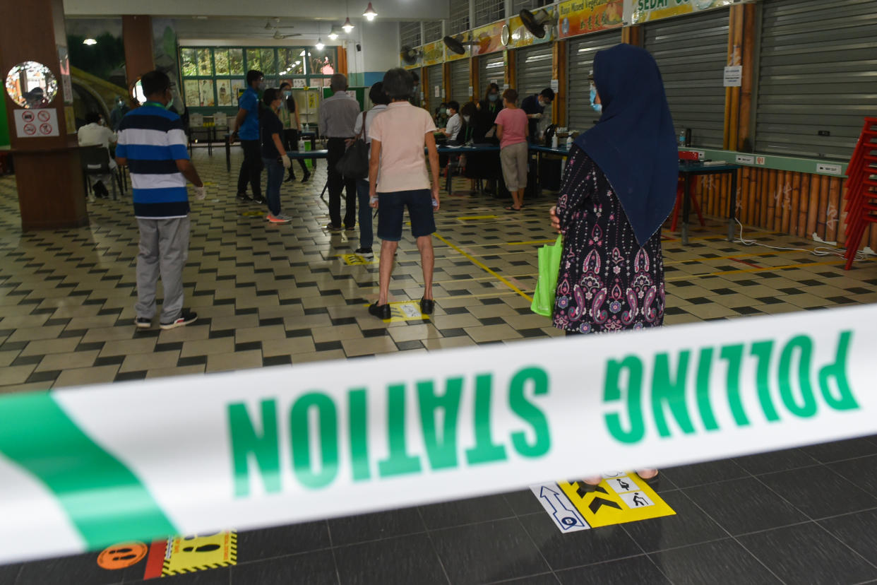 Voters observe social distancing to prevent the spread of the COVID-19 novel coronavirus as they wait to vote during the general election in Singapore on July 10, 2020. - Wearing masks and gloves and being careful to observe social distancing, Singaporeans voted in a general election on July 10 as the city-state struggles to recover from a serious coronavirus outbreak. (Photo by Roslan RAHMAN / AFP) (Photo by ROSLAN RAHMAN/AFP via Getty Images)