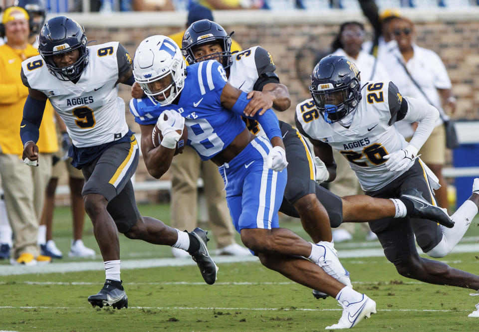 Duke's Jordan Moore (8) carries the ball ahead of North Carolina A&T's Janaz Sumpter (9), Henry Daniel (34), and Ty Williams Jr. (26) during the first half of an NCAA college football game in Durham, N.C., Saturday, Sept. 17, 2022. (AP Photo/Ben McKeown)