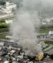 Smoke billows from a Kyoto Animation building, right bottom, in Kyoto, western Japan, Thursday, July 18, 2019. The fire broke out in the three-story building in Japan's ancient capital of Kyoto, after a suspect sprayed an unidentified liquid to accelerate the blaze, Kyoto prefectural police and fire department officials said.(Kyodo News via AP)