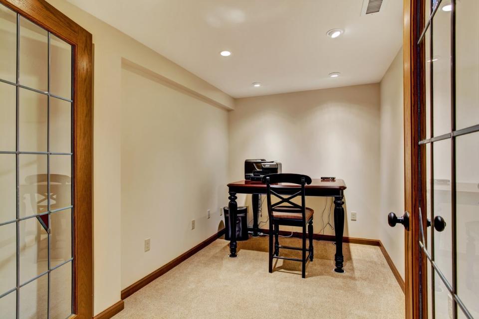 Small office room interior in soft ivory with wooden desk and chair