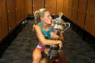 Germany's Angelique Kerber kisses the trophy in the locker room after winning her final match against Serena Williams of the U.S. at the Australian Open tennis tournament at Melbourne Park, Australia, in this January 30, 2016 handout photo. REUTERS/Fiona Hamilton/Handout via Reuters