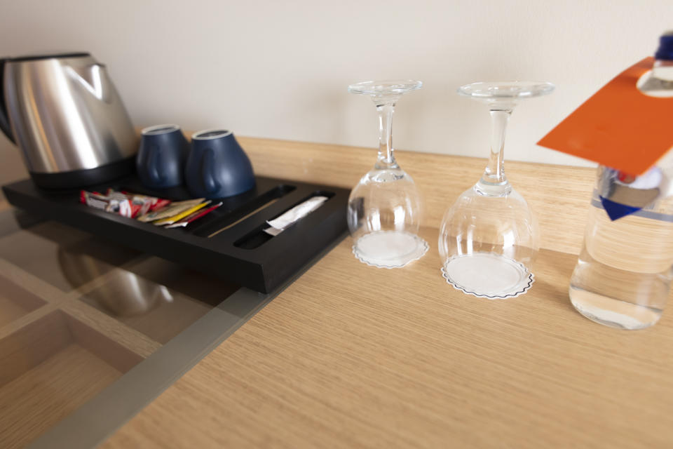 Hotel room desk with a hospitality tray, kettle, cups, and complimentary items for guests