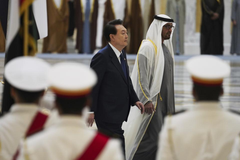 South Korean President Yoon Suk Yeol, center left, and Emirati leader Sheikh Mohammed bin Zayed Al Nahyan walk past an honor guard at Qasar Al Watan in Abu Dhabi, United Arab Emirates, Sunday, Jan. 15, 2023. Yoon received an honor guard welcome Sunday on a trip to the United Arab Emirates, where Seoul hopes to expand its military sales while finishing its construction of the Arabian Peninsula's first nuclear power plant. (AP Photo/Jon Gambrell)