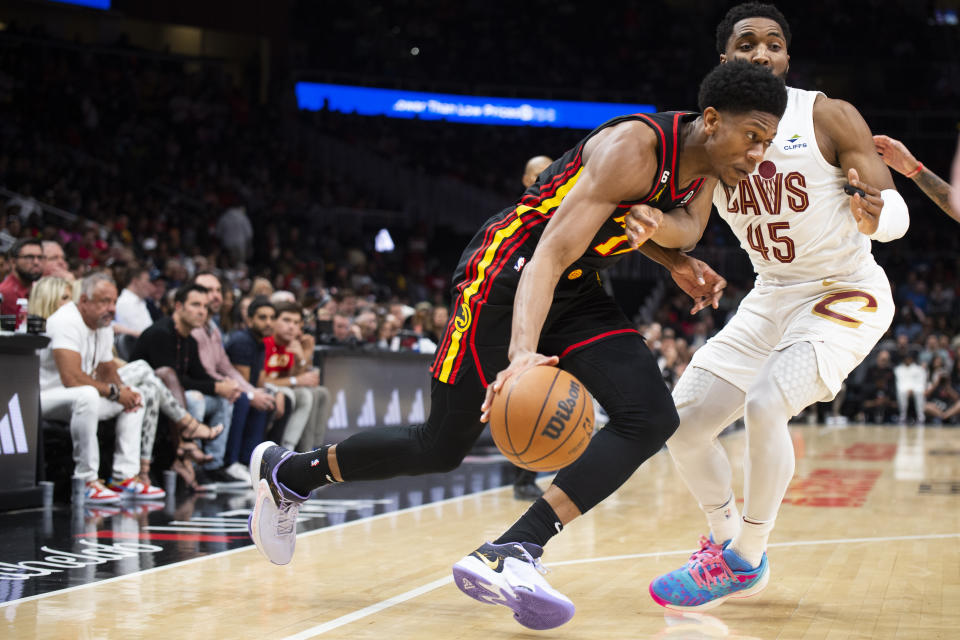 Atlanta Hawks forward De'Andre Hunter drives to the basket against Cleveland Cavaliers guard Donovan Mitchell during the first half of an NBA basketball game Tuesday, March 28, 2023, in Atlanta. (AP Photo/Hakim Wright Sr.)