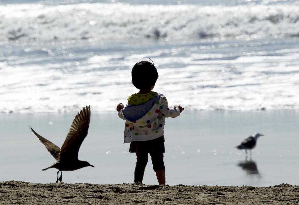 A little girl enjoys the warm weather in the Venice Beach area of Los Angeles, Friday, Feb. 14, 2014. With much of the Northeast gripped by snow and ice storms, the Southwest is riding a heat wave that is setting record high temperatures and sent people to beaches and golf courses in droves Friday. (AP Photo/Damian Dovarganes)