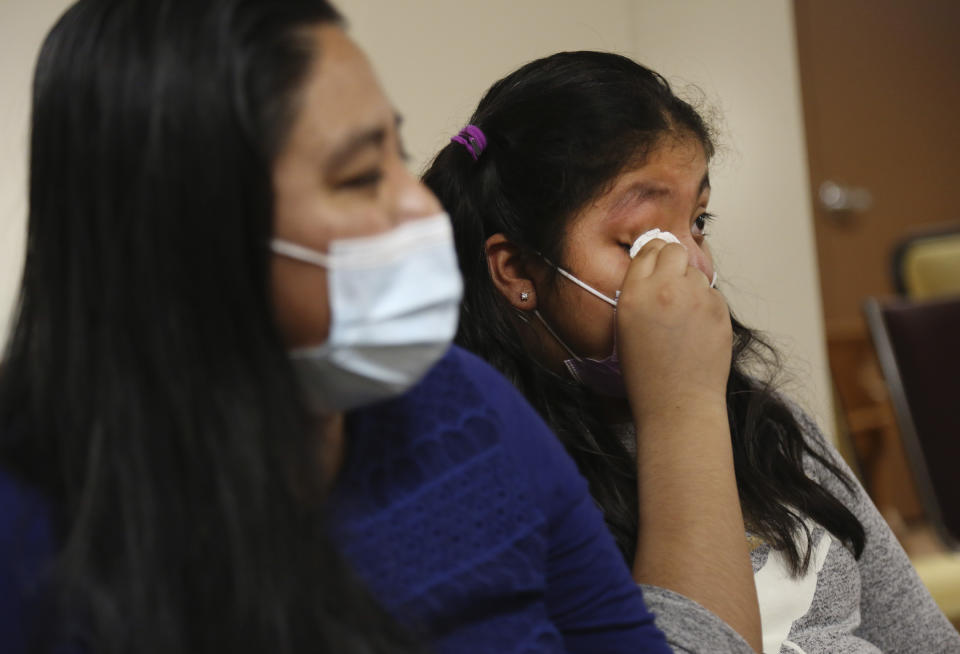 Stephany Martinez wipes tears from her eyes as she talks about losing her grandparents to the coronavirus, while sitting next to her mother, Reyna Martinez, at Our Lady of Sorrows Roman Catholic church in the Queens borough of New York on Friday, March 5, 2021. Both are parishioners of the church. (AP Photo/Jessie Wardarski)