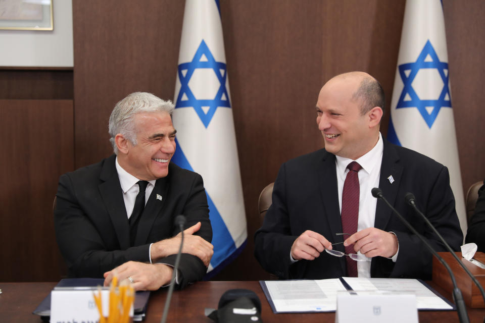 FILE - Israeli Prime Minister Naftali Bennett, right, and Foreign Minister Yair Lapid attend a cabinet meeting at the Prime Minister's office in Jerusalem, June 19, 2022. Bennett's office announced Monday, June 20, 2022, that his weakened coalition will be disbanded and the country will head to new elections. Bennett and his main coalition partner, Yair Lapid, decided to present a vote to dissolve parliament in the coming days, Bennett's office said. Lapid is then to serve as caretaker prime minister. The election, expected in the fall, would be Israel's fifth in three years. (Abir Sultan/Pool Photo via AP, File)