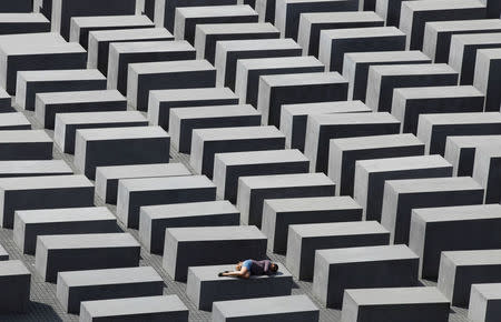 FILE PHOTO: A girl rests on a concrete column of the Holocaust memorial in Berlin, Germany, June 17, 2011. REUTERS/Tobias Schwarz/File Photo