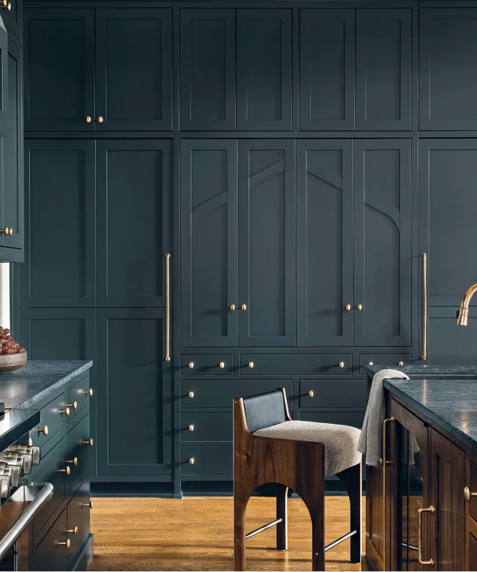 Dark kitchen with tall cabinetry and brass knobs