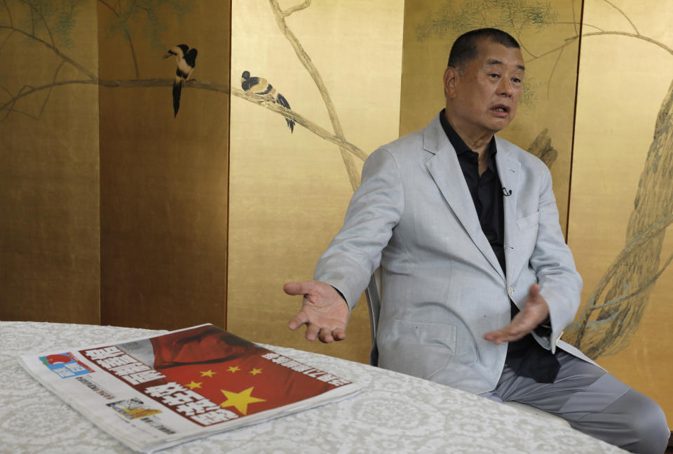 Hong Kong media tycoon Jimmy Lai gesture next to a copy of Apple Daily's July 1 edition during an interview Hong Kong Wednesday, July 1, 2020. Lai said in an interview Wednesday that Hong Kong is dead under the new national security law. Lai, who owns popular newspaper Apple Daily, is a prominent advocate for democracy in Hong Kong. (AP Photo/Vincent Yu)