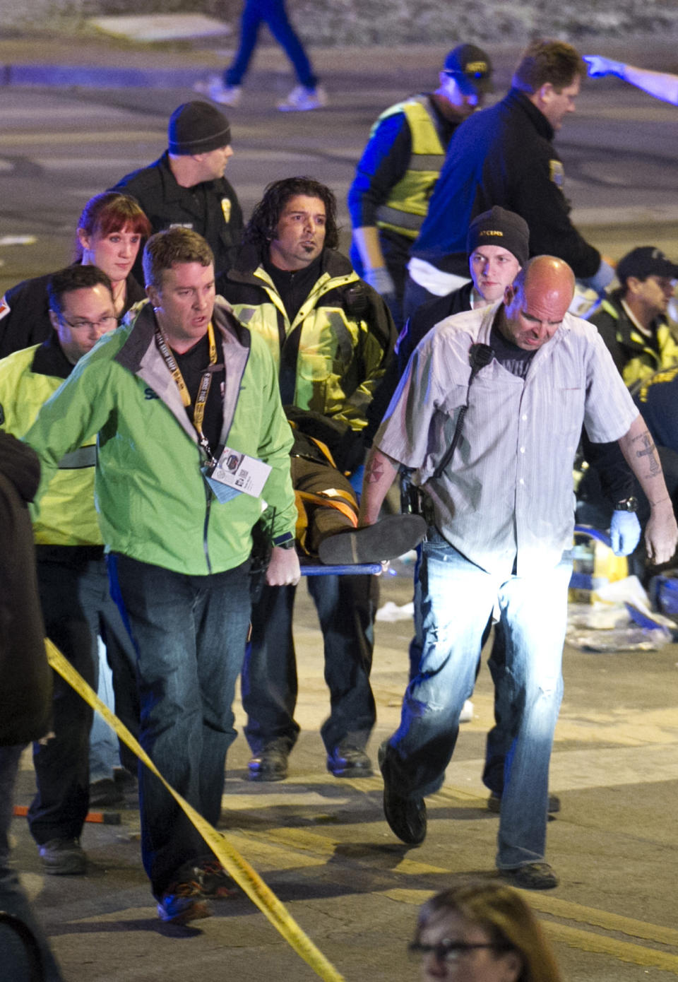 People carry a person who was struck by a car on Red River Street in downtown Austin, Texas, on Wednesday, March 12, 2014. Police say a man and woman have been killed after a suspected drunken driver fleeing from arrest crashed through barricades set up for the South By Southwest festival and struck the pair and others on a crowded street. (AP Photo/Austin American-Statesman, Jay Janner)