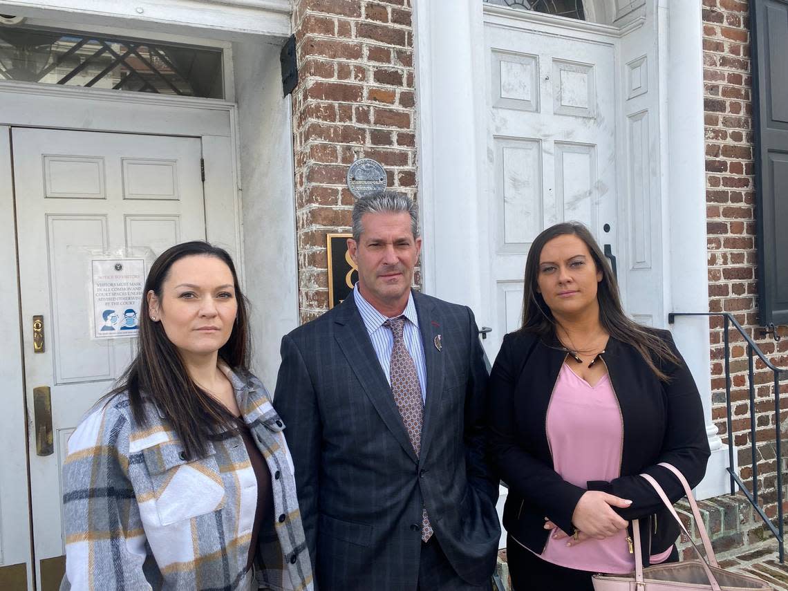Sisters Alania Plyler Spohn, 30, and Hannah Plyler, 24, with their attorney Eric Bland, stand outside the Charleston federal courthouse on Monday, Nov. 14, 2022. Both testified at the federal fraud trial of former bank official Russell Laffitte.