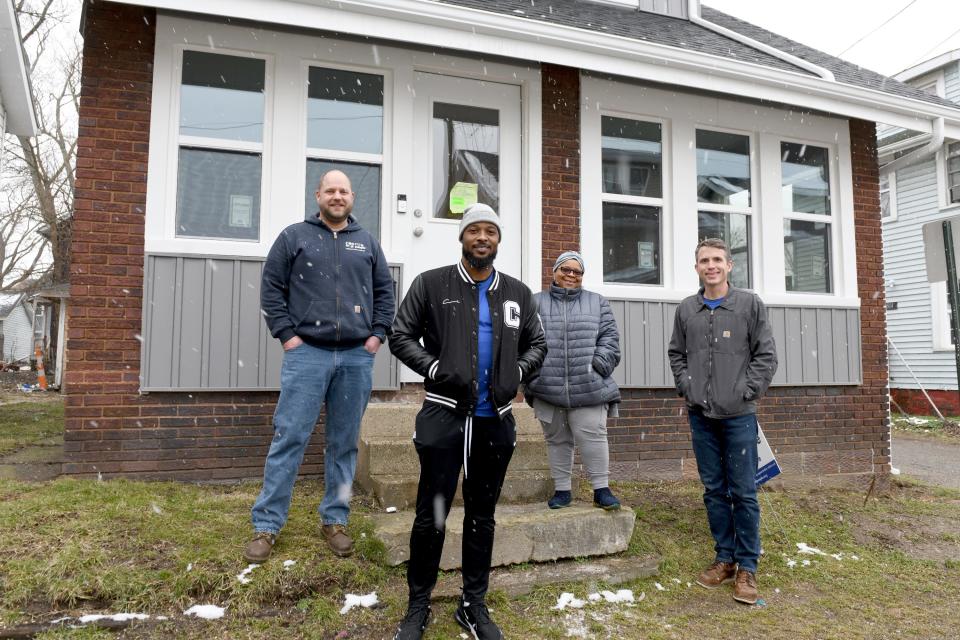 Managing Director Mike Farmer, Community Organizer Gino Hayes, Housing Navigator Cynthia Hammond and Executive Director Don Ackerman outside a house Canton For All People renovated in the greater Shorb neighborhood.
