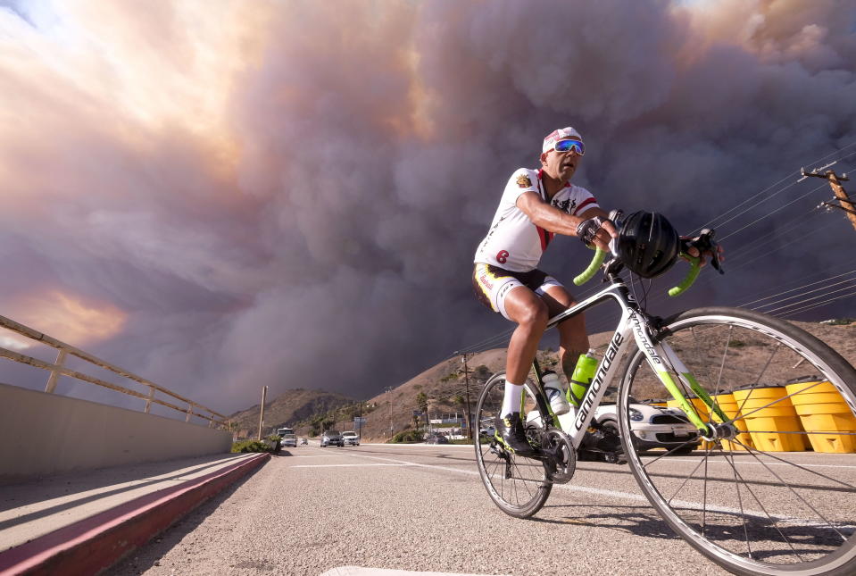 <p>A man rides on along the Pacific Coast Highway as the heavy smoke rises over the the Santa Monica Mountains during the Woolsey fire in Malibu, Calif., Friday, Nov. 9, 2018.<br>(Photo from Ringo H.W. Chiu, AP) </p>
