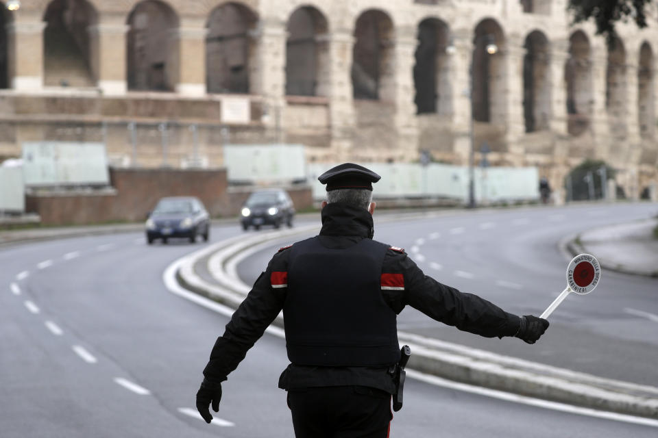 Italian Carabinieri officers check vehicles near the Colosseum in Rome, Thursday, Dec. 24, 2020. Italians are easing into a holiday season full of restrictions, and already are barred from traveling to other regions except for valid reasons like work or health. Starting Christmas eve, travel beyond city or town borders also will be blocked, with some allowance for very limited personal visits in the same region. (AP Photo/Gregorio Borgia)