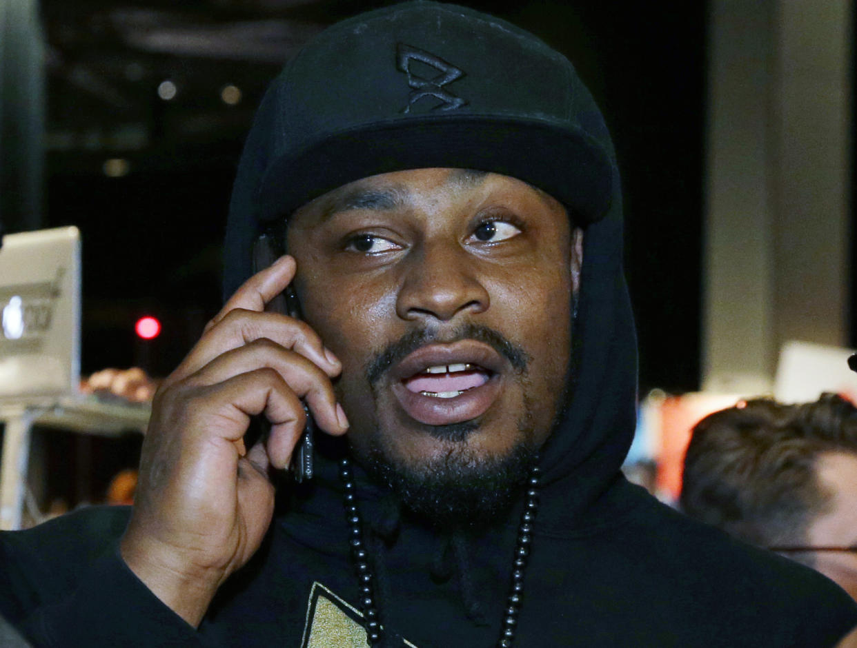 FILE - In this May 5, 2016, file photo, Marshawn Lynch talks on the phone after giving a speech at a job fair in Seattle. Lynch is putting to rest any lingering speculation about a possible return to the NFL in an interview with "60 Minutes Sports." In the interview that is to air Tuesday, June 7, 2016, Lynch says, "I'm retired. Is that good enough? (AP Photo/Ted S. Warren, File)