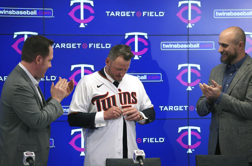 The Minnesota Twins new third baseman Josh Donaldson, flanked by team executive Derek Falvey, left, and manager Rocco Baldelli, puts on a jersey as he is introduced during a baseball news conference Wednesday, Jan. 22, 2020, at Target Field in Minneapolis. (Brian Peterson/Star Tribune via AP)