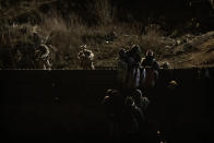 U.S. Border Protection officers point their weapons at migrants as they prepare to cross the border fence to get into the U.S. side to San Diego, Calif., from Tijuana, Mexico, Tuesday, Jan. 1, 2019. Discouraged by the long wait to apply for asylum through official ports of entry, many migrants from recent caravans are choosing to cross the U.S. border wall and hand themselves in to border patrol agents. (AP Photo/Daniel Ochoa de Olza)