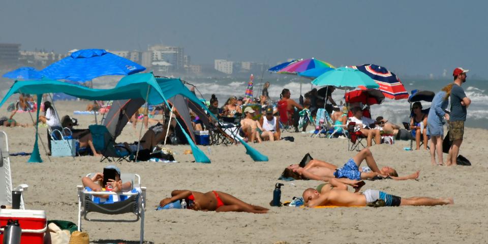 Beachgoers in the area across from the 5th Avenue Boardwalk on a weekday in Indialantic.