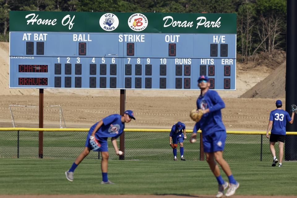 Chatham Anglers players warm up before a Cape Cod League baseball game against the Bourne Braves, Wednesday, July 12, 2023, in Bourne, Mass. For 100 years, the Cape Cod League has given top college players the opportunity to hone their skills and show off for scouts while facing other top talent from around the country. (AP Photo/Michael Dwyer)