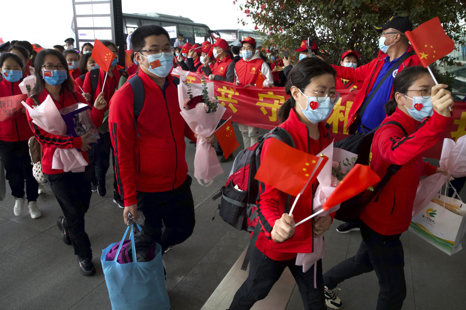 Medical workers from Jilin Province wave Chinese flags as they prepare to return home, at Wuhan Tianhe International Airport.