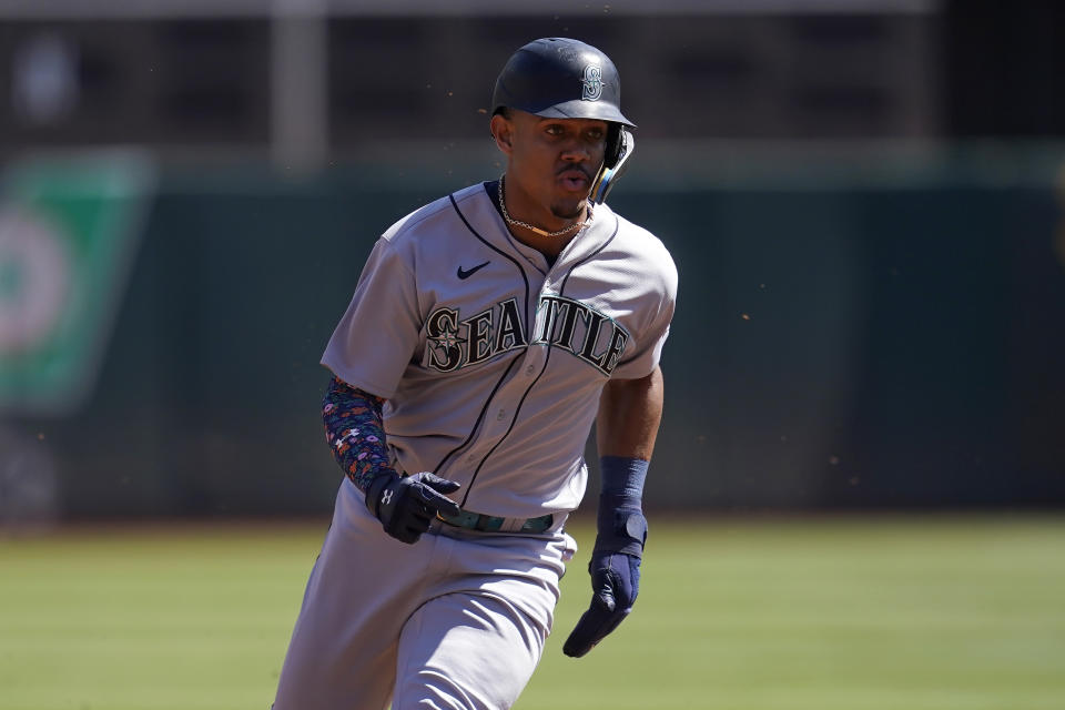 Seattle Mariners' Julio Rodriguez rounds third base to score on a single by Mitch Haniger during the first inning of a baseball game against the Oakland Athletics in Oakland, Calif., Thursday, Sept. 22, 2022. (AP Photo/Jeff Chiu)
