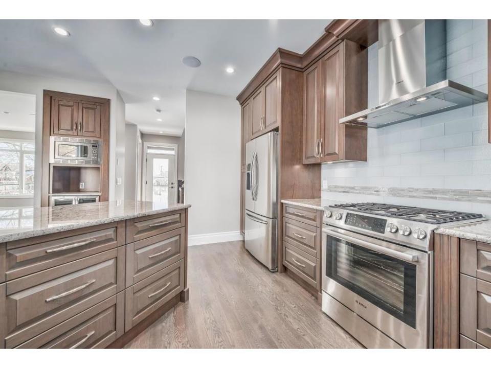 <p><span>616 3 Avenue Northwest, Calgary, Alta.</span><br> The kitchen features cherry wood cabinets, stainless steel appliances and granite countertops.<br> (Photo: Zoocasa) </p>