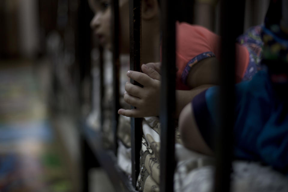 FILE - In this Aug. 16, 2018 file photo, a child peeks out from her crib at Salhiya Orphanage, which now hosts foreign and Iraqi children of Islamic State militants, in Baghdad, Iraq. (AP Photo/Maya Alleruzzo, File)