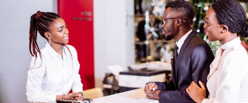 african Car rental assistant giving information to couple customer