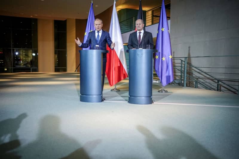 Polish Prime Minister Donald Tusk (L) and German Chancellor Olaf Scholz speak during a press conference after their meeting at the Federal Chancellery. Kay Nietfeld/dpa
