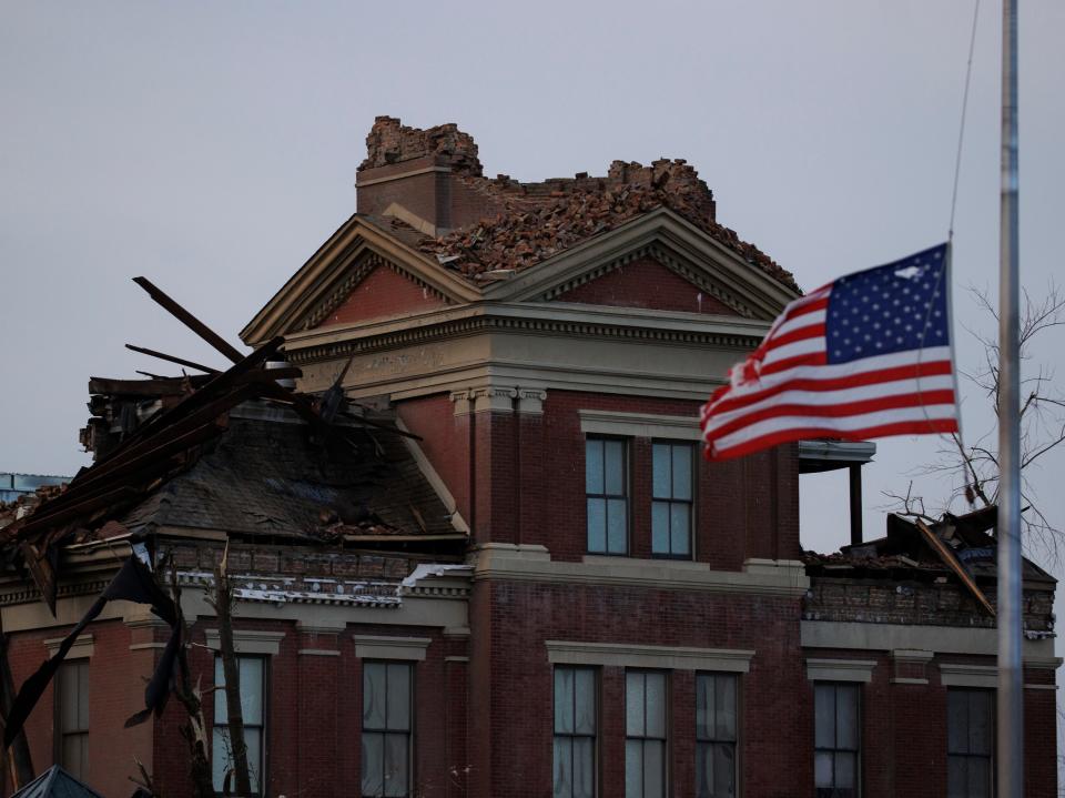 A tattered American flag flies at half-mast for Sen. Bob Dole in front of the heavy tornado-damaged courthouse on December 11, 2021 in Mayfield, Kentucky (Getty Images)