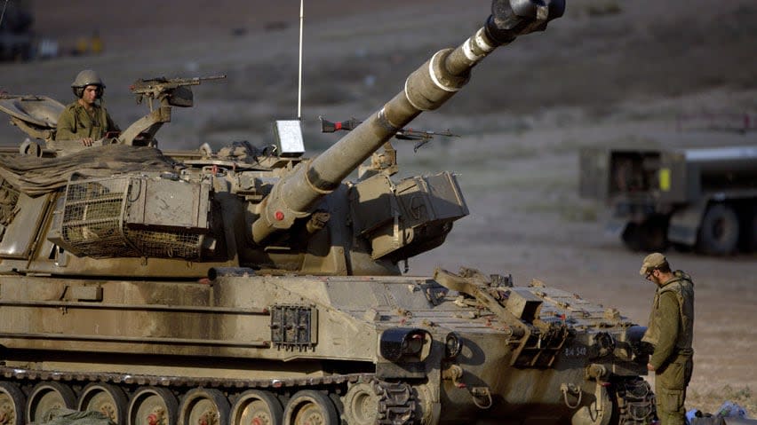 An Israeli artillery crew near the Israel and Gaza border prepares to fire towards Gaza.