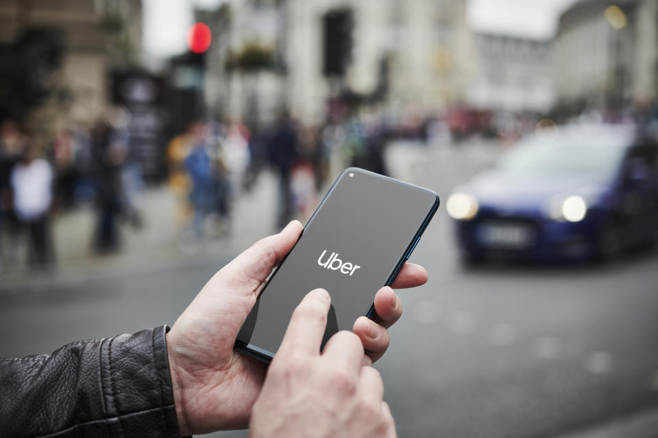 LONDON, UNITED KINGDOM - JUNE 4: Detail of a man holding up an Honor 20 Pro smartphone with the Uber transport app visible on screen, while taxis queue in the background, on June 4, 2019. (Photo by Olly Curtis/Future via Getty Images via Getty Images)