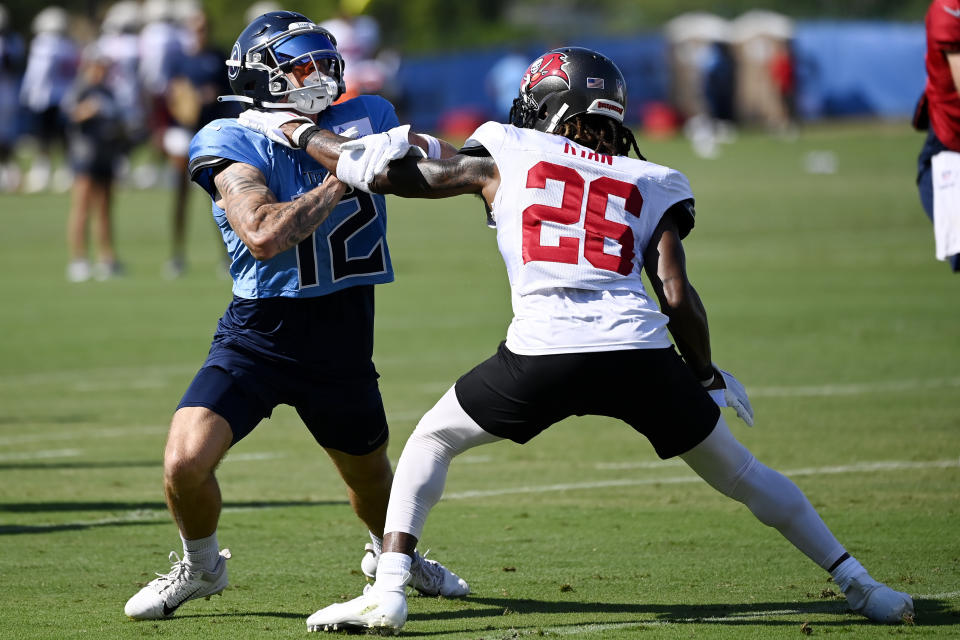 Tennessee Titans wide receiver Mason Kinsey (12) tries to run around Tampa Bay Buccaneers cornerback Logan Ryan (26) in a passing drill during a combined NFL football training camp Thursday, Aug. 18, 2022, in Nashville, Tenn. (AP Photo/Mark Zaleski)