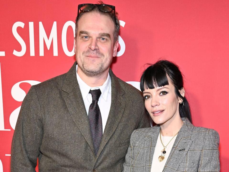 David Harbour, in a tweet jacket, poses for photos on the red carpet with Lily Allen, in a plaid blazer.