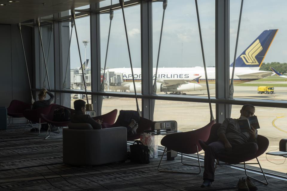 Travelers in a waiting area near a Singapore Airlines Ltd. aircraft at Changi Airport in Singapore, on Wednesday, March 30, 2022. Photographer: Ore Huiying/Bloomberg