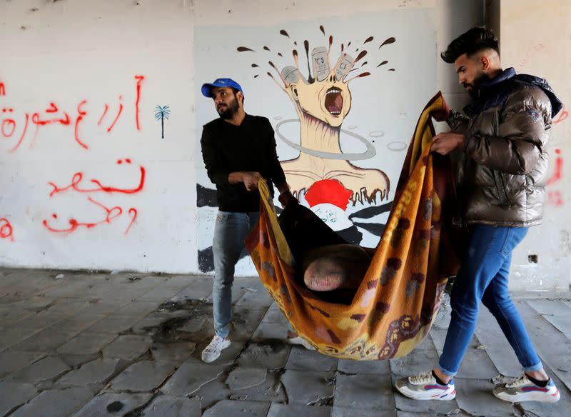 Supporters of Iraqi Shi'ite cleric Moqtada al-Sadr known as "blue hats" work at the high-rise building during ongoing anti-government protests in Baghdad