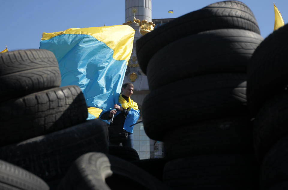 An activist holds a Ukrainian flag during a rally in the Independence Square in Kiev, Sunday, April 6, 2014. Thousands have gathered every Sunday on Independence Square, which served as the focus of protests that led to the toppling of President Viktor Yanukovych in February, to demand that the interim government live up to its promises. (AP Photo/Sergei Chuzavkov)
