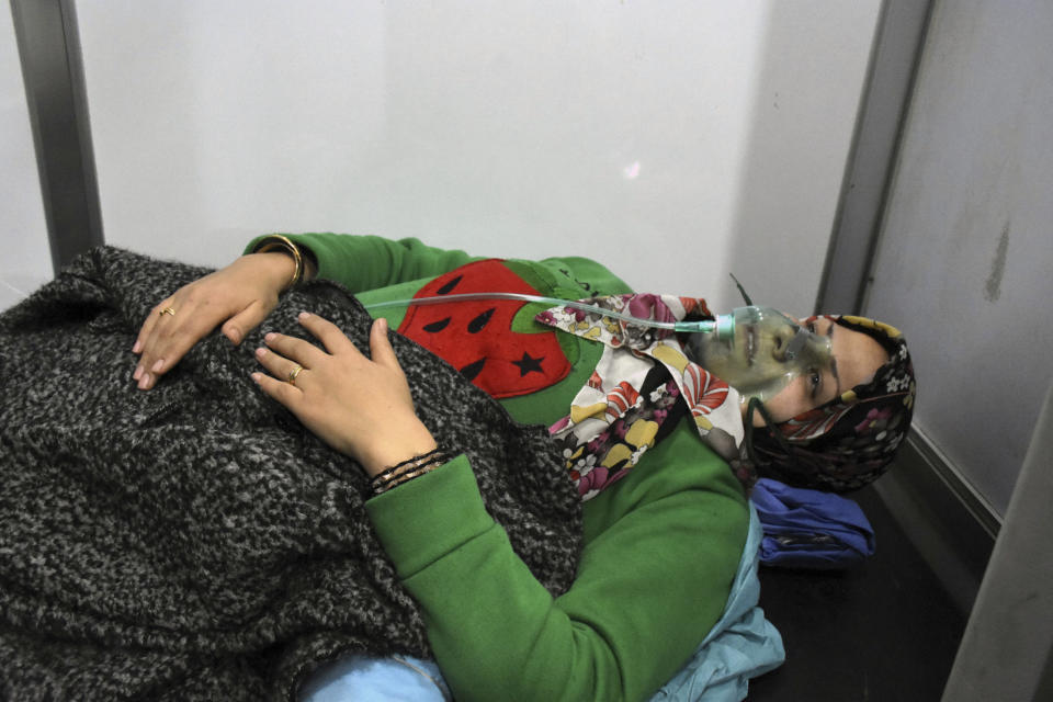 In this photo released by the Syrian official news agency SANA, shows a woman receiving oxygen through respirators following a suspected chemical attack on her town of al-Khalidiya, in Aleppo, Syria, Saturday, Nov. 24, 2018. Some 50 civilians were being treated following a suspected poison gas attack by Syrian rebel groups on the government-held Aleppo city in the country's north, according to Syrian state media. (SANA via AP)