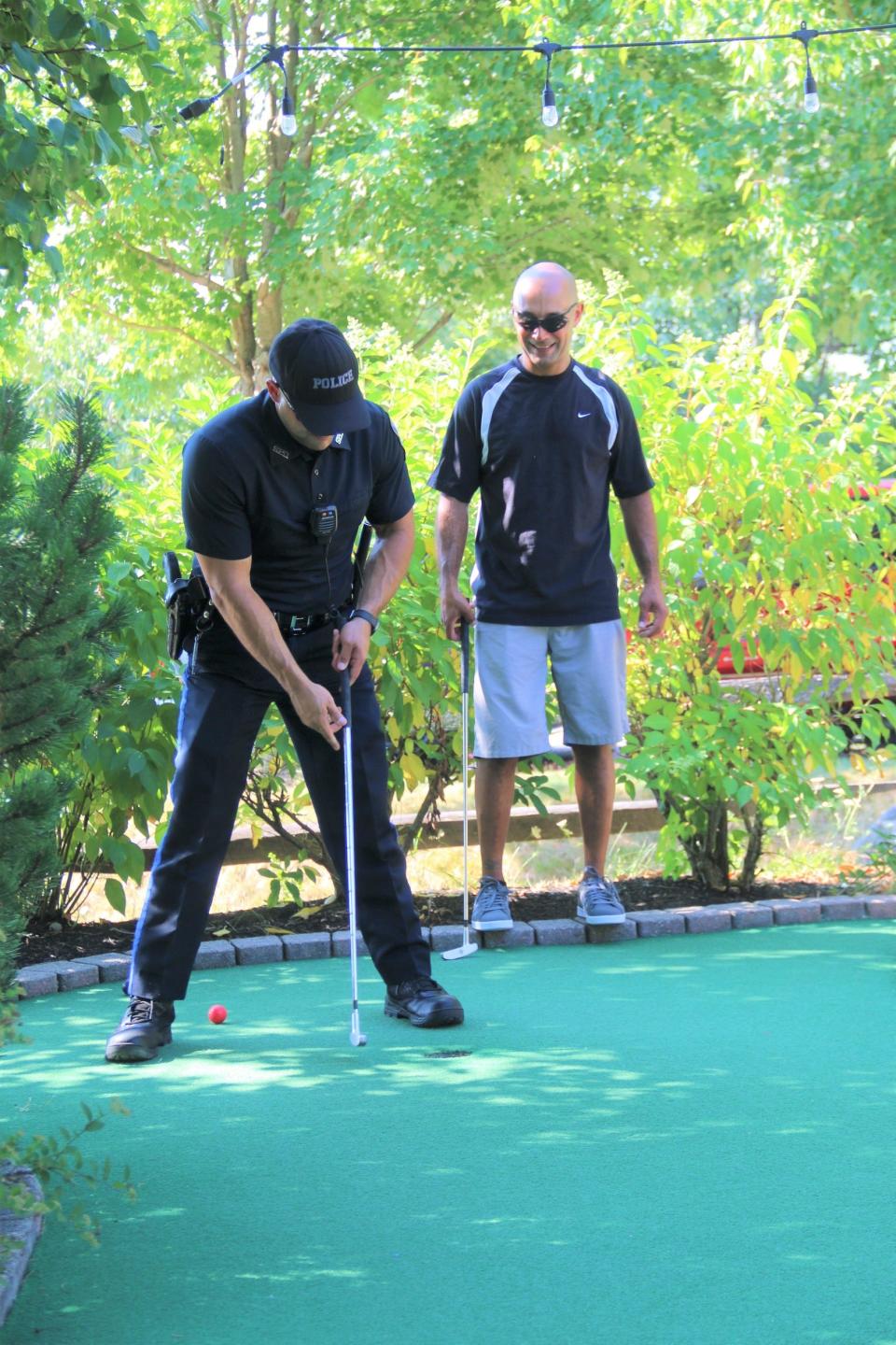 Police officers Steve Mucci (left) and Fil Santos, dressed a bit more conservatively than the firefighters, enjoy the round.