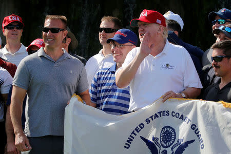 U.S. President Donald Trump stands with U.S. Coast Guard Chief Warrant Officer Gene Gibson (L), commanding officer of the Lake Worth Inlet Station, as Trump plays host to members of the U.S. Coast Guard he invited to play golf at his Trump International Golf Club in West Palm Beach, Florida, U.S., December 29, 2017. REUTERS/Jonathan Ernst