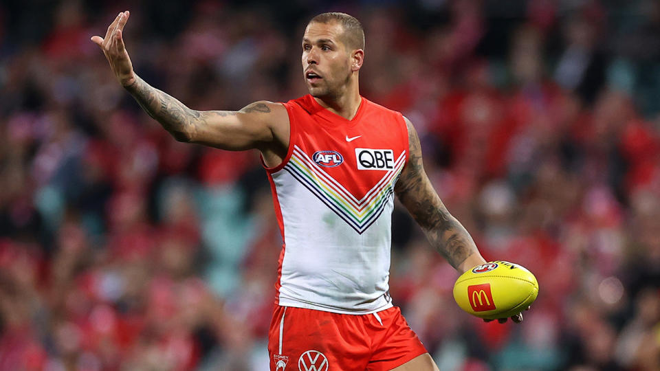 Lance Franklin gestures towards teammates during an AFL game.