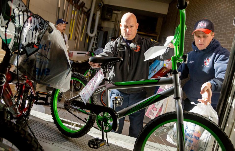 Lt. John Ferrell, left, and Cpl. Tanner Goodwin load toys that members of Oklahoma City Fire Department Station No. 1 purchased for foster care children in 2016.