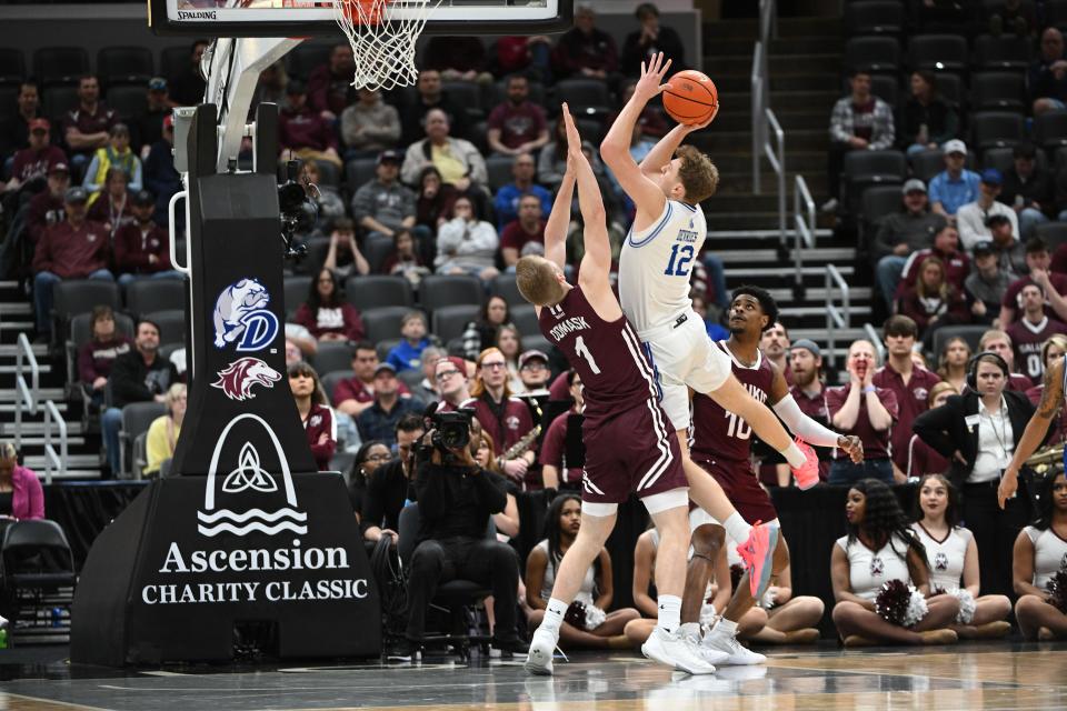 Tucker DeVries (12) takes a shot over Marcus Domask (1) during a MVC Tournament semifinal between Drake men's basketball and Southern Illinois.