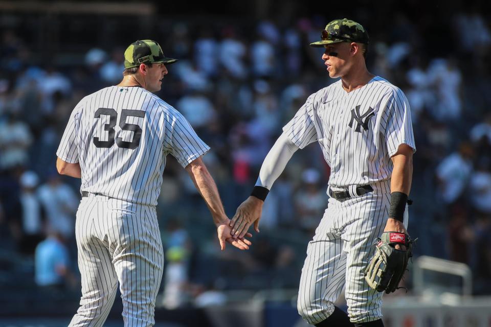 May 21, 2022; Bronx, New York, USA; New York Yankees relief pitcher Clay Holmes (35) and center fielder Aaron Judge (99) congratulate each other after defeating the Chicago White Sox 7-5 at Yankee Stadium. Mandatory Credit: Wendell Cruz-USA TODAY Sports
