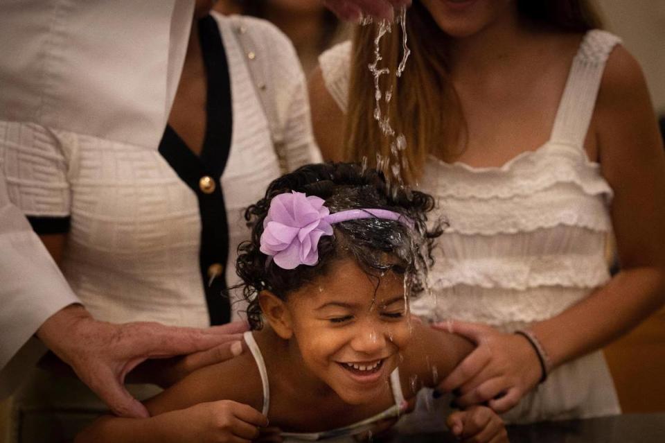 La hija de Karen Ugás es bautizada por el padre José Menéndez el domingo 10 de septiembre de 2023 en la iglesia católica Corpus Christi de Miami. Muchos de los niños bautizados eran refugiados inmigrantes acogidos en la iglesia como parte de un esfuerzo de los Hermanos de la Calle, una organización que lucha contra la falta de vivienda. Alie Skowronski askowronski@miamiherald.com Alie Skowronski/askowronski@miamiherald.com