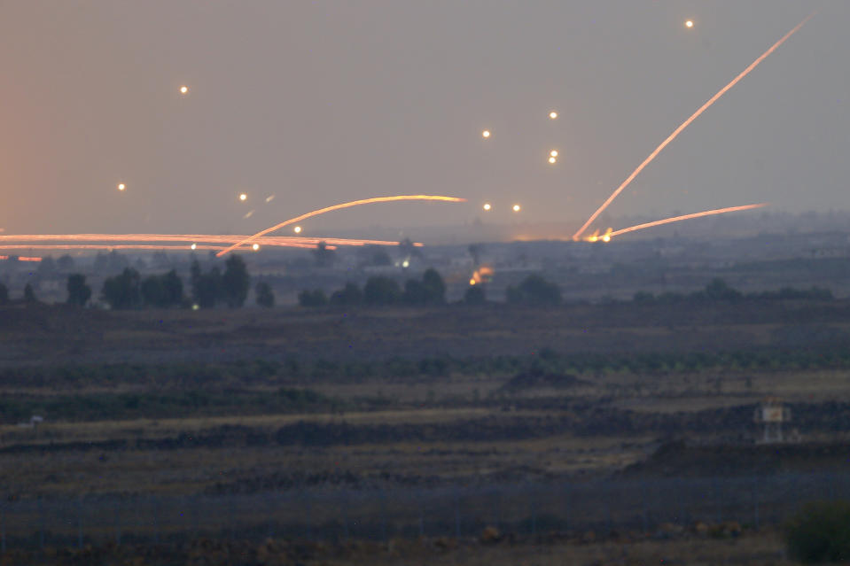 Fire trails and explosions from the fighting between forces loyal to Syrian President Bashar Assad and rebels in southern Syria as seen from the Israeli-controlled Golan Heights, Wednesday, July 25, 2018. (AP Photo/Ariel Schalit)