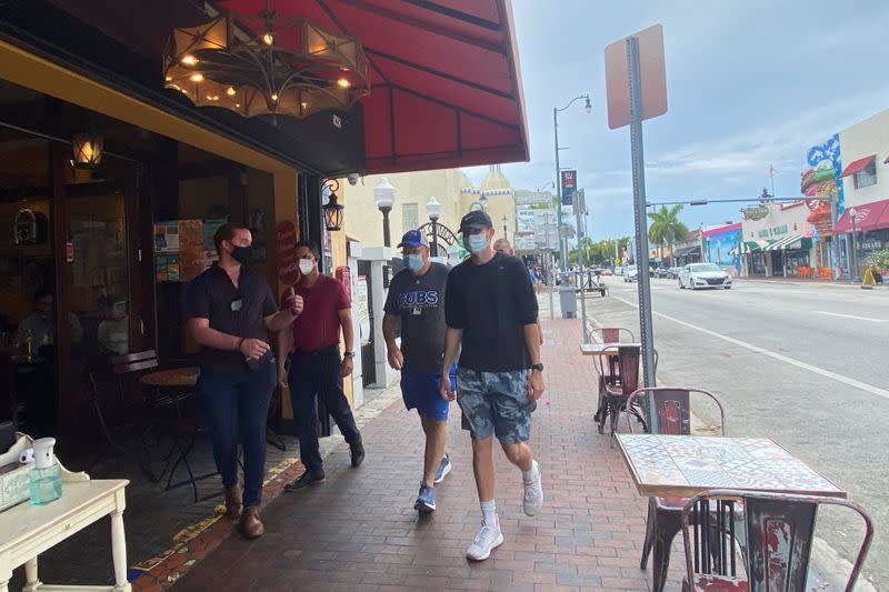 Un anfitrión reparte desinfectante para manos a los clientes que ingresan a Old's Havana Cuban Bar & Cocina en Miami