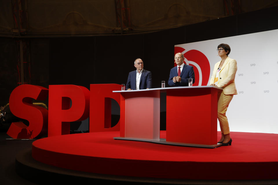 German Finance Minister Olaf Scholz, center, and the Social Democratic Party leaders Saskia Esken, right, und Norbert Walter-Borjans, left, attend a news conference in Berlin, Germany, Monday, Aug. 10, 2020. The SPD announced that Olaf Scholz will run for the party as chancellor candidate at next year's general elections in Germany. (AP Photo/Markus Schreiber)
