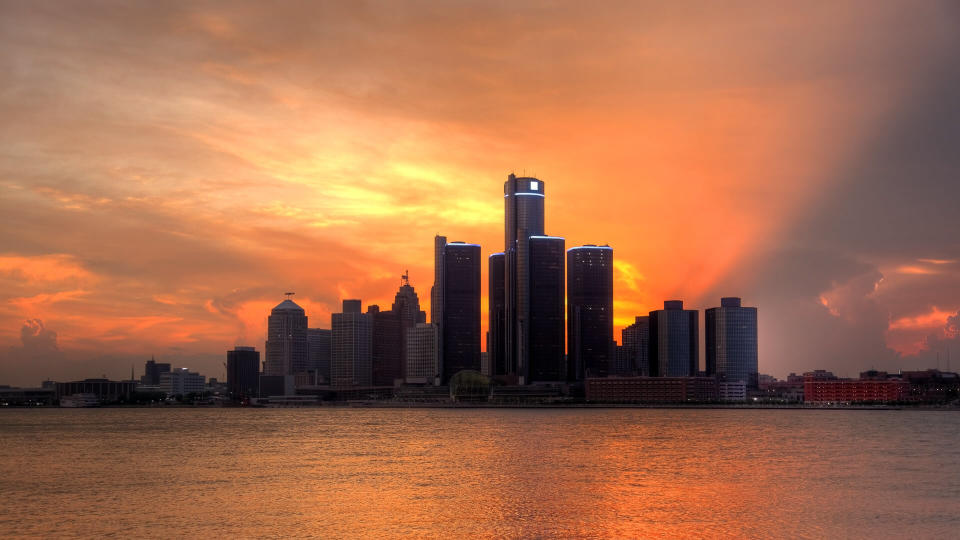 Detroit city skyline along the Detroit River at sunset.